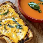 For the cheesy grilled toast, you need: - 4 slices of whole grain bread - 1 cup shredded sharp cheddar cheese - 1 cup shredded mozzarella cheese - 1 tablespoon unsalted butter, softened These ingredients create a tasty base. The bread gives a nice crunch, while the cheeses melt perfectly for that gooey texture you want. To make the tomato soup, gather: - 1 can (14 oz) crushed tomatoes - 1 cup vegetable broth - 1 small onion, finely chopped - 2 cloves garlic, minced - 1 teaspoon dried basil - 1 teaspoon sugar - Salt and pepper to taste These items come together to create a rich and comforting soup. The crushed tomatoes are the star, while the onion and garlic add depth of flavor. Enhance your meal with these optional garnishes: - Fresh basil leaves for garnish Adding fresh basil brightens the dish. You can also try a sprinkle of cheese on top for extra delight. Want more ideas? You can check the Full Recipe for more! To make the tomato soup, start with a medium saucepan. Heat a splash of olive oil over medium heat. Add one small, chopped onion and sauté it until soft, around five minutes. Next, stir in two minced garlic cloves and cook for one more minute. This step brings out the nice garlic flavor. Now, pour in one can of crushed tomatoes and one cup of vegetable broth. Add one teaspoon of dried basil, one teaspoon of sugar, salt, and pepper to taste. Bring it all to a simmer. Let it cook for 15 to 20 minutes on low heat, stirring now and then. When it’s ready, use an immersion blender to puree the soup until smooth. If the soup seems too thick, add more broth to get the right texture. While the soup simmers, let’s make the grilled toast. Take four slices of whole grain bread and spread one tablespoon of softened unsalted butter on one side of each slice. On the unbuttered side of two slices, layer half of the shredded sharp cheddar and mozzarella cheese. Place the second slice of bread on top, with the buttered side out. This makes a nice sandwich. Heat a skillet over medium heat. Once it's hot, add the sandwiches to the pan. Cook for about three to four minutes on each side until the bread is golden and the cheese is melted. Repeat this with the other slices and cheese. Once cooked, cut the grilled toast into triangles. Serve them next to warm bowls of creamy tomato soup. If you like, garnish with fresh basil leaves for some color and taste. Enjoy your comforting meal of cheesy grilled toast and tomato soup! For the full recipe, check the earlier section. To make grilled toast that is golden and crispy, start with good bread. Whole grain works great. Spread a thin layer of softened butter on one side of each slice. This helps it brown well. Heat your skillet over medium heat. Don't rush! If it’s too hot, the bread will burn. Cook for about 3-4 minutes per side. Flip when golden brown. Don’t forget to check often. You want melted cheese, too! For a rich tomato soup, use crushed tomatoes, not whole ones. Cooking onion and garlic first adds depth. Let them soften to bring out their flavors. Adding dried basil gives the soup a nice herbal note. Sugar helps balance the acidity of the tomatoes. Taste before serving! If it needs more salt or pepper, now is the time. Adjust to your liking. A smooth texture is key, so use an immersion blender for the best results. One mistake is not heating the skillet enough. If it's too cool, the bread won't crisp. Another is adding too much salt at once. Always taste before you add more. Overcooking the soup can make it too thick. If it gets thick, add more broth to fix it. Lastly, don’t skip the garnish! Fresh basil adds color and flavor. With these tips, your cheesy grilled toast and tomato soup will shine. Check out the Full Recipe for more details! {{image_2}} You can change the cheese to make your toast unique. Try using gouda, pepper jack, or even blue cheese. Each cheese adds its own flavor and texture. Mixing different cheeses can create a richer taste. For example, a blend of mozzarella and gouda makes it creamy. You can also add some parmesan on top for a crunchy finish. The cheese you pick can make each bite a new experience. Tomato soup can be so much more than just tomato. Start by adding spices like cumin or chili powder for warmth. You can also stir in some cooked vegetables like carrots or bell peppers. This adds color and nutrition. If you like it creamy, add a splash of cream or coconut milk. For a fresh twist, squeeze in some lemon juice right before serving. These small changes can lift your soup to a new level. Serving your dish can be fun! Instead of a bowl, use mugs for the soup. This makes it feel cozy. You can also serve the grilled toast on a cutting board for a rustic look. Try adding fresh herbs or a drizzle of olive oil on the soup. It makes the dish look fancy. Pair it with a simple salad for a full meal. These ideas make your cheesy grilled toast and tomato soup feel special and inviting. For the full recipe, check the details above. To keep your leftover tomato soup fresh, let it cool first. Transfer it to an airtight container. Store it in the fridge for up to four days. You can also freeze it. Use a freezer-safe container or bag. It will last for about three months in the freezer. When ready to eat, thaw it overnight in the fridge. Grilled toast is best enjoyed right away. If you have extras, wrap them in foil or plastic wrap. Place them in the fridge for up to two days. This helps prevent them from becoming soggy. For longer storage, freeze them. Just make sure to wrap them tightly. They can last for up to three months in the freezer. To reheat your tomato soup, pour it into a saucepan. Heat it on low, stirring often. You can also use a microwave. Just heat in short bursts, stirring in between. For grilled toast, reheat in a toaster oven. This keeps them crispy. If using a microwave, place a paper towel on the plate to absorb moisture. Enjoy your meal warm and tasty! For the full recipe of this delicious dish, check the Full Recipe. Yes, you can use fresh tomatoes. Start with about 2 pounds of ripe tomatoes. Blanch them in boiling water for a minute, then cool them in ice water to peel. Chop them up and add them to your soup. Fresh tomatoes will give your soup a bright taste. Just remember to adjust your cooking time. Fresh tomatoes may take longer to break down compared to canned ones. For grilled cheese, I love using whole grain bread. It adds a nutty flavor and good texture. You can also try sourdough or white bread for a classic taste. Look for bread that can hold a lot of cheese without falling apart. A thick slice gives you a nice crunch when grilled. Always choose bread that you enjoy eating. This recipe is already vegetarian! The soup uses vegetable broth, making it perfect for plant lovers. If you want to add more veggies, consider mixing in some spinach or bell peppers. Just sauté them with the onion for extra flavor. Make sure your bread is free from animal products if you want it fully vegetarian. Enjoy your meal! In this post, I covered the key ingredients for cheesy grilled toast and rich tomato soup. You learned how to prepare both dishes step-by-step. I shared tips for perfect toast, flavorful soup, and common mistakes to avoid. We also explored fun variations and storage tips. Finally, make this classic meal yours by experimenting with ingredients and flavors. Happy cooking!