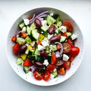 - 2 large cucumbers, diced - 1 cup cherry tomatoes, halved - 1 medium red onion, thinly sliced - 1 bell pepper (red or yellow), diced - 1 cup Kalamata olives, pitted - 1 cup feta cheese, crumbled - 2 tablespoons fresh dill, chopped - 3 tablespoons olive oil - 2 tablespoons lemon juice - 1 teaspoon dried oregano - Salt and pepper to taste For this Cucumber Dill Greek Salad, fresh ingredients are key. Start with crisp cucumbers. They add crunch and hydration. I like to use large ones. Slice them into bite-sized pieces. Next, grab cherry tomatoes. Halve them for a juicy burst in every bite. They bring sweetness that balances the dish. A medium red onion adds a sharp flavor. Thinly slice it to keep the texture soft. Bell peppers, either red or yellow, bring color and sweetness. Dice them into small pieces. Kalamata olives provide a briny contrast. Make sure they are pitted for easy eating. Feta cheese is a must; its creaminess enhances every mouthful. Crumble it on top for a delightful taste. Fresh dill is my secret weapon. It adds a fragrant note that ties everything together. For the dressing, use olive oil and lemon juice. They create a bright and zesty flavor. Dried oregano adds an earthy touch. Lastly, season with salt and pepper to elevate all the tastes. Gather these ingredients, and you're on your way to making a refreshing dish. {{ingredient_image_1}} Start by dicing the cucumbers into bite-sized pieces. Next, halve the cherry tomatoes and add them to a large mixing bowl. Thinly slice the red onion and dice the bell pepper. Toss all these fresh veggies together in the bowl for a colorful mix. Now, it&rsquo;s time to add flavor. Toss in the Kalamata olives, pitted and whole, for a briny kick. Crumble the feta cheese over the top. The creamy feta adds richness that pairs perfectly with the crisp vegetables. In a small bowl, whisk together the olive oil and fresh lemon juice. This creates a zesty base for the dressing. Next, chop the dill and add it to the bowl. Sprinkle in the dried oregano, salt, and pepper to taste. Whisk until all the ingredients blend into a smooth dressing. Pour the dressing over the salad mixture. Use a gentle tossing motion to coat all the ingredients evenly. This helps every bite burst with flavor. After mixing, let the salad sit for about 10 minutes. This marinating time allows the flavors to blend and enhances the overall taste. Serve your salad chilled or at room temperature for the best experience. To make a great Cucumber Dill Greek Salad, start with fresh ingredients. Look for firm cucumbers that feel heavy for their size. The skin should be bright and shiny. For tomatoes, choose cherry tomatoes that are plump and vibrant. They should smell sweet and earthy. When selecting feta cheese, opt for the block variety instead of crumbled. This type has better flavor and texture. Look for cheese packed in brine, as it stays fresh longer. If you can, try to find sheep's milk feta. It adds a rich taste that enhances the salad. To boost the flavor, consider adding fresh herbs like parsley or mint. Chopped green onions can also add a nice touch. You can sprinkle in a bit of crushed red pepper if you like heat. For marinating, let the salad sit for at least 10 minutes before serving. This allows the flavors to blend. Toss the salad again before serving to refresh the ingredients. Serve the salad chilled or at room temperature. This keeps it refreshing. It pairs well with grilled chicken, lamb, or fish. You can also serve it alongside pita bread or hummus for a light meal. Enjoy this vibrant dish as a side or main course! Pro Tips Use Fresh Ingredients: Choose the freshest cucumbers, tomatoes, and herbs for the best flavor and texture in your salad. Chill Before Serving: Allow the salad to sit in the refrigerator for at least 10 minutes before serving to enhance the flavors. Customize Your Veggies: Feel free to add other vegetables like radishes or carrots for extra crunch and color. Feta Storage Tips: Keep leftover feta cheese submerged in olive oil in the fridge to maintain freshness and flavor. {{image_2}} You can swap out Kalamata olives for green olives or capers. These options give a different taste. For feta cheese, try goat cheese for a tangy twist. You can also use ricotta for a creamier texture. Feel free to mix in other veggies. Chopped carrots or radishes add crunch. You can also use zucchini or celery for a fresh bite. The goal is to keep it light and refreshing. Making this salad gluten-free is simple. All the ingredients listed are naturally gluten-free. Just ensure any added ingredients do not contain gluten. For a vegan version, skip the feta cheese. You can use avocado for creaminess instead. Nutritional yeast also adds a cheesy flavor without dairy. In summer, add fresh corn or diced avocados for a creamy touch. You can try diced strawberries for sweetness too. In winter, consider using roasted vegetables like sweet potatoes. They add warmth and depth to the salad. You can also include citrus like oranges for brightness during colder months. After enjoying your Cucumber Dill Greek Salad, you may have leftovers. Store the salad in an airtight container. This keeps the flavors fresh. If you have a large amount, divide it into smaller containers. This way, you can grab a quick snack. Be sure to keep the salad in the fridge. It will stay crispy and tasty. Glass or plastic containers work best for salad. They seal tight and let you see inside. Avoid metal containers, as they can change the taste. Knowing how long each ingredient lasts is key to good storage. Cucumbers stay fresh for about a week. Cherry tomatoes last about five days in the fridge. Red onions can last up to two weeks. Bell peppers keep for about a week. Kalamata olives and feta cheese have a longer shelf life. They can last for a couple of weeks if stored properly. Just make sure these are sealed well to keep them fresh. You can prepare the Cucumber Dill Greek Salad ahead of time. Just wait to add the dressing until you are ready to serve. This keeps the veggies from getting soggy. Chop the cucumbers, tomatoes, onion, and bell pepper a day before. Store them in the fridge. Mix the dressing in a jar and keep it in the fridge too. On serving day, combine everything and toss. Enjoy the fresh flavors without losing quality! To make your dressing creamier, add plain yogurt or sour cream. These will give your dressing a nice texture. You can also use mayonnaise for a richer flavor. Mix these ingredients with olive oil and lemon juice to keep the fresh taste. A creamy dressing pairs well with the crisp veggies. Yes, you can prepare the salad a day in advance. Just keep the dressing separate until you are ready to serve. This way, your salad stays fresh and crunchy. Mix the salad ingredients, cover, and store in the fridge. When it's time to eat, add the dressing and toss. If you don&rsquo;t have fresh dill, you can use dried dill instead. Use about one teaspoon of dried dill for every tablespoon of fresh. Other herbs like parsley or cilantro also work well. They will change the flavor a bit but still taste great. This salad offers refreshing flavors with simple ingredients and easy steps. Start with fresh veggies and tasty dressing. Use my tips to enhance your dish. Feel free to switch up ingredients for your taste or diet. Store leftovers properly to keep them fresh. Enjoy making this salad soon, and remember: cooking can be fun and simple!