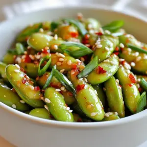 - Fresh or frozen edamame in pods - Garlic - Soy sauce - Sesame oil - Chili flakes - Honey or agave syrup - Sesame seeds - Green onions - Salt To make spicy garlic edamame, you need simple, fresh ingredients. Let&rsquo;s dive into what you should gather: 1. Edamame: Choose fresh or frozen pods. Both work well. If using frozen, they cook fast. 2. Garlic: Use four cloves. Minced garlic gives great flavor. 3. Soy Sauce: This adds saltiness and depth. It&rsquo;s your umami booster. 4. Sesame Oil: One tablespoon adds a nutty taste. Use it to saut&eacute; the garlic. 5. Chili Flakes: Use one teaspoon, or more for heat. Adjust to your taste. 6. Honey or Agave Syrup: This adds a sweet balance. One teaspoon is enough. 7. Sesame Seeds: These are for garnish. They add crunch and look great. 8. Green Onions: Finely chop two for garnish. They bring freshness and color. 9. Salt: Just a pinch to taste. Don&rsquo;t forget to check the flavor! These ingredients come together to create a tasty snack. Each one plays a role in the final dish. Prepare them before you start cooking. That makes the process smooth and fun! {{ingredient_image_1}} First, fill a pot with water. Bring it to a boil. If you use frozen edamame, add it to the pot. Cook the edamame for about 5 minutes. You want them tender but not mushy. Once cooked, drain the edamame in a colander. Set them aside while you prepare the spicy garlic mix. Next, grab a medium skillet and heat 1 tablespoon of sesame oil over medium heat. This oil adds a nice nutty flavor. Once the oil is hot, add 4 cloves of minced garlic. Saut&eacute; the garlic for about 1 to 2 minutes. Keep an eye on it to prevent burning. You want it fragrant, not brown. Now, stir in 2 tablespoons of soy sauce, 1 teaspoon of honey or agave syrup, and 1 teaspoon of chili flakes. Mix well and cook for another minute. This lets the flavors blend. After that, add the cooked edamame to the skillet. Toss everything together until the edamame is well coated. Cook for an extra 2 to 3 minutes. This helps the edamame soak up all the spicy goodness. Taste and add salt if needed before serving. - Adjust the chili flakes to your taste. If you like it hot, add more. If you prefer mild, use less. - You can substitute soy sauce with tamari for a gluten-free option. Use coconut aminos for a sweeter taste. - Avoid burning the garlic. Cook it just until fragrant, about 1-2 minutes. Stir it often to keep it from browning. - To ensure the edamame absorbs the flavors, toss them well in the spicy mixture. Cook for an extra 2-3 minutes after adding them. - Serve the edamame in a large bowl for sharing. This makes it fun for everyone. - Garnish with sesame seeds and chopped green onions. This adds color and a fresh crunch. Pro Tips Fresh Edamame for Best Flavor: If possible, use fresh edamame instead of frozen for a more vibrant flavor and better texture. Adjust Spice Level: Feel free to modify the amount of chili flakes according to your heat preference. Start with less if you&rsquo;re unsure! Garnish for Visual Appeal: Adding the sesame seeds and green onions not only enhances flavor but also adds a pop of color to the dish. Serving Suggestions: Serve these edamame as a snack, appetizer, or as a side dish to complement Asian-inspired meals. {{image_2}} To make this dish vegan, replace honey with agave syrup. Agave syrup has a similar sweetness. It blends well with the other flavors. This swap keeps the dish plant-based while still tasting great. You can make your Spicy Garlic Edamame even better by adding extra ingredients. Consider incorporating vegetables like bell peppers or carrots. These add color and crunch. You might also want to add protein options like tofu or tempeh. These choices turn your appetizer into a heartier dish. For those who enjoy heat, consider using different types of chili. You can try fresh chilies or chili paste for more depth. Experimenting with sauces can also bring new flavors. For example, sriracha or sambal can elevate the spice level. Mix and match to find your perfect heat balance. Store your spicy garlic edamame in an airtight container. This keeps them fresh and tasty. Leftovers last about 3 days in the fridge. Make sure to cool them down before sealing. This prevents moisture build-up, which can make them soggy. You can freeze edamame too. First, let them cool completely. Then, place them in freezer-safe bags. Remove as much air as possible before sealing. They can stay good for up to 3 months. When you're ready to eat, take out the amount you need. To defrost, place them in the fridge overnight. You can also microwave them for a few minutes. To reheat, use the stovetop or microwave. If using the stovetop, heat them in a pan over low heat. This helps keep their texture firm. If using the microwave, cover them with a damp paper towel. This keeps them from drying out. Avoid high heat to prevent a mushy texture. Enjoy every bite! You can serve Spicy Garlic Edamame with many dishes. It pairs well with rice or noodles. You can also enjoy it with sushi or as part of a vegetable platter. If you like a protein, try chicken or tofu. A light salad can also balance the spice. Yes, you can prepare this recipe ahead of time. Cook the edamame and store it in the fridge. Keep the garlic mixture separate. When you are ready to serve, just warm them both up and combine. This keeps the flavors fresh and tasty. No, edamame pods are not edible. They are tough and fibrous. Only eat the beans inside the pods. The beans are safe and healthy to eat. They are full of protein and fiber, making them a great snack. Select edamame that feels firm in the pod. Look for bright green color without brown spots. If buying frozen, choose bags with no ice crystals. Fresh edamame should have a slight sheen. These tips ensure you get quality beans for your dish. In this post, we explored how to make spicy garlic edamame, starting with fresh ingredients. Boiling the edamame and mixing it with a spicy garlic sauce creates a tasty dish. I shared tips for adjusting flavor, cooking techniques, and fun serving ideas. You can even try vegan options or add extra veggies to shake things up. Remember, proper storage and reheating keep your leftovers tasty. Enjoy making this dish, and let your creativity shine in the kitchen!