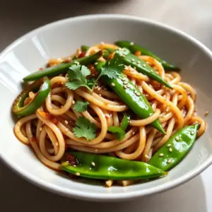 - 200g noodles (preferably udon or ramen) - 3 tablespoons honey - 2 tablespoons soy sauce - 2 tablespoons sesame oil - 4 cloves garlic, minced - 1 teaspoon ginger, grated - 1 tablespoon chili paste (adjust to taste) - 1 green bell pepper, sliced - 1 cup sugar snap peas - 2 spring onions, sliced - 1 tablespoon sesame seeds (for garnish) - Fresh cilantro for garnish (optional) For noodles, udon or ramen are best. You can swap them for rice noodles if you prefer. Honey adds sweetness, but maple syrup works too. Use tamari instead of soy sauce for a gluten-free option. Sesame oil has a unique taste, but can be replaced with canola oil in a pinch. If you like more heat, add more chili paste or use fresh chili. Garnishes make the dish pop. Sesame seeds add crunch and flavor. Fresh cilantro brightens the dish with a bit of freshness. You can also use chopped peanuts for more texture. Thinly sliced lime wedges add a nice zesty touch if you like some tang. {{ingredient_image_1}} Start by boiling salted water in a big pot. Add the noodles and cook them according to the package instructions. They should be al dente, which means they should have a little bite to them. After cooking, drain the noodles and rinse them with cold water. This stops the cooking and keeps them firm. Set the noodles aside for later. In a bowl, mix together honey, soy sauce, sesame oil, minced garlic, grated ginger, and chili paste. Whisk everything until it blends well. This sauce gives the noodles their sweet and spicy kick. You can adjust the chili paste based on how spicy you like it. Heat a teaspoon of sesame oil in a large frying pan or wok over medium-high heat. Add the sliced green bell pepper and sugar snap peas. Stir-fry them for about 3-4 minutes. You want them to soften a bit but still stay crunchy. This adds color and texture to your dish. Now, add the cooked noodles into the pan with the veggies. Pour the sauce mixture over the noodles. Toss everything together until the noodles are fully coated. Keep stirring for about 2-3 minutes until everything is hot. This step is key for flavor! Take the pan off the heat and stir in the sliced spring onions. Plate the noodles and sprinkle sesame seeds on top. You can also add fresh cilantro if you like. This not only adds flavor but also gives your dish a nice look. Enjoy your tasty meal! To get the best texture in your noodles, cook them just right. Follow the package instructions for timing. Aim for al dente; they should be firm but not hard. After cooking, drain and rinse the noodles in cold water. This stops them from cooking more and keeps them nice and chewy. Want to change the heat? Start with one teaspoon of chili paste. If you like it hot, add more. Taste as you go! Mixing in some extra honey can help balance the spice if it gets too hot. Remember, you can always add more spice, but it's hard to take it out. To boost the flavor, try adding fresh herbs. Cilantro adds a great taste. You can also sprinkle in some lime juice for a zesty kick. If you want a richer flavor, mix in a splash of rice vinegar. These small tweaks make a big difference and can fit your taste buds perfectly! Pro Tips Fresh Ingredients: Use fresh garlic and ginger for the best flavor. They can significantly enhance the taste of your sauce. Adjust Spice Levels: Feel free to adjust the amount of chili paste based on your heat preference. Start with less if you're unsure, and add more as needed. Vegetable Variations: Experiment with different vegetables like broccoli or carrots for added texture and nutrition. Leftover Noodles: If you have leftover noodles, store them in an airtight container in the fridge. Reheat them in a pan with a splash of water to prevent sticking. {{image_2}} You can easily make this dish vegetarian or vegan. Replace honey with maple syrup or agave nectar. Both options offer sweetness and taste great. Ensure your soy sauce is vegan-friendly. This way, you keep the flavor while meeting dietary needs. Want to change the taste? Swap the noodles for rice noodles or even whole wheat noodles. Try different veggies too! Broccoli, carrots, or bok choy work well. You can also use different sauces. Replace soy sauce with tamari for a gluten-free option. Experiment with other spices like garlic powder or red pepper flakes for extra heat. You can add a local twist to these noodles. Use local vegetables that are in season. Try adding bell peppers or snow peas, which are often found in many regions. For a bit of zest, add lime or lemon juice. You can even sprinkle fresh herbs like basil or mint for a unique flavor. These small changes make the dish your own. To keep your Spicy Honey Garlic Noodles fresh, store them in an airtight container. Let the noodles cool down first. Then, cover the container tightly. They can stay in the fridge for up to three days. This way, they stay tasty and safe to eat. When you’re ready to eat the leftovers, reheat them gently. I suggest using a pan over low heat. Add a splash of water or more sesame oil to keep them moist. Stir often and heat until warm. You can also use the microwave. Heat in short bursts, stirring in between, until hot. You can freeze these noodles for later use. First, cool the noodles completely. Then, put them in a freezer-safe bag or container. Remove as much air as possible to prevent freezer burn. They will keep well for about one month. To use, thaw overnight in the fridge, then reheat as described above. I recommend using udon or ramen noodles. They hold sauce well and taste great. You can find these at most grocery stores. Other options include rice noodles or soba, but they change the flavor slightly. Yes, you can prep the sauce and chop the veggies in advance. Store them in the fridge. Cook the noodles fresh for the best texture. If you need to make it all ahead, just reheat and mix before serving. To make this dish gluten-free, use gluten-free soy sauce. You can also use rice noodles instead of wheat noodles. Both swaps keep the flavor tasty without gluten. Serve these noodles with grilled chicken or shrimp for extra protein. You can also add sautéed mushrooms or bok choy for more veggies. For a crunch, sprinkle more sesame seeds on top. Pair with a light salad or steamed broccoli for a complete meal. We discussed key ingredients, from measurements to optional garnishes, to get it just right. I shared step-by-step instructions for cooking noodles, making the sauce, and mixing them. I offered tips to achieve perfect texture and flavor. You learned variations to cater to different diets and storage tips for leftovers. Cooking should be fun and simple. Explore your options and make this dish your own! Enjoy your tasty creation.